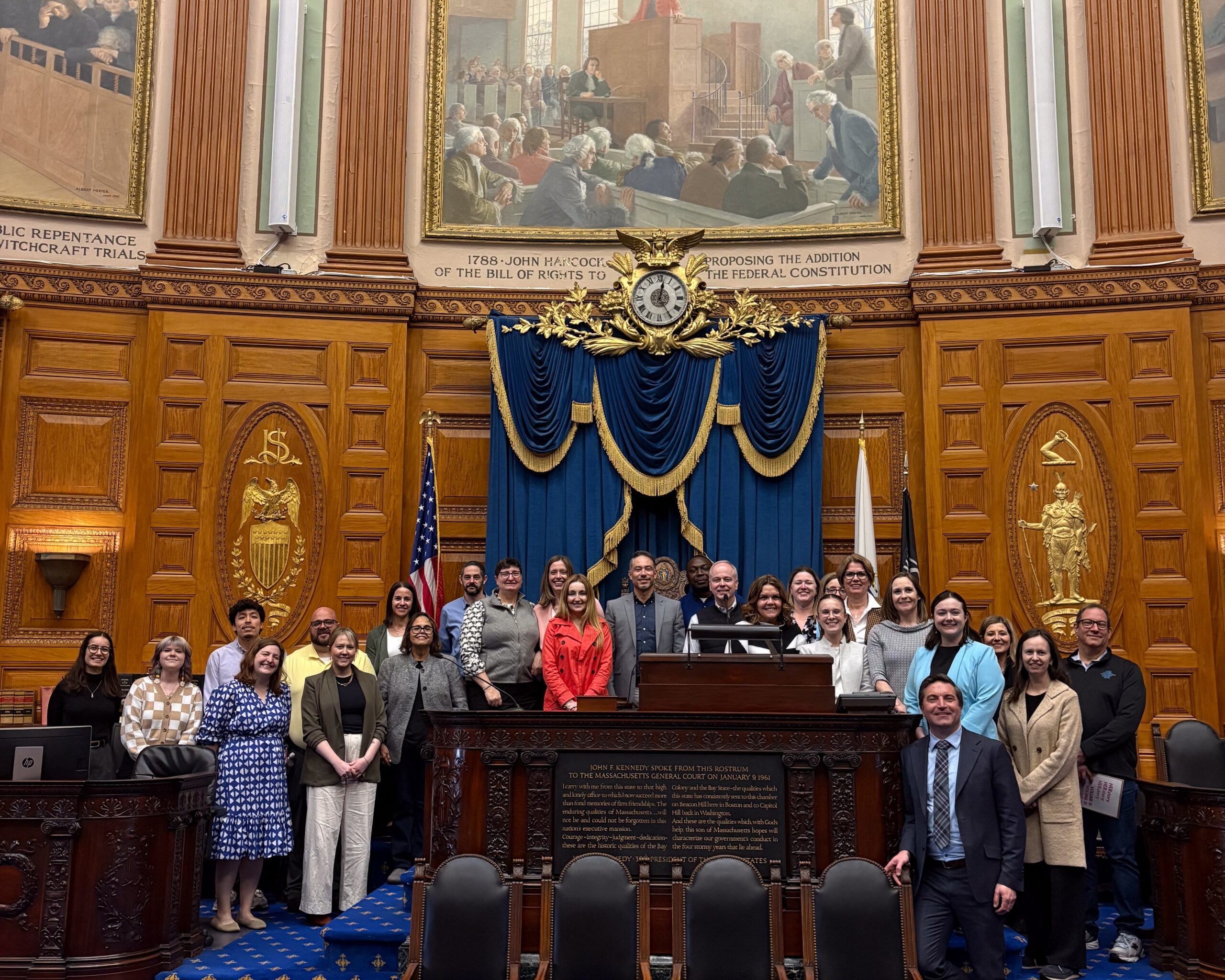 Leadership Academy '26 stands on the MA State House dias with Rep Jack Patrick Lewis